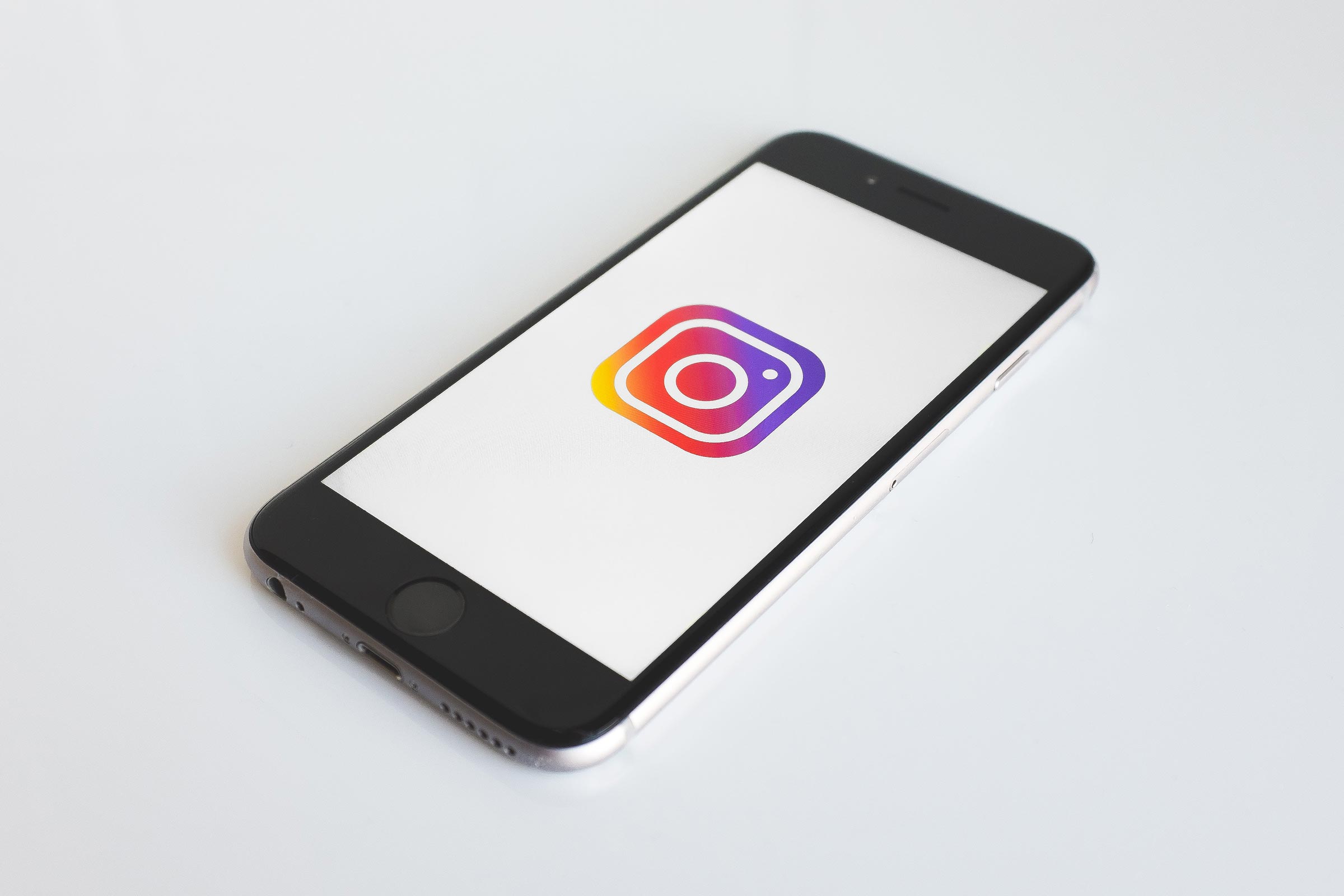 5 Expert Tips to Get More Engagement on Instagram Phone with Instagram logo on the screen